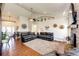 Spacious living room with high ceilings, fireplace, hardwood floors, and plush leather furniture at 59466 E Commanche Way, Strasburg, CO 80136