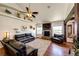 Inviting living room with a brick fireplace, hardwood floors, and comfortable leather sofas at 59466 E Commanche Way, Strasburg, CO 80136