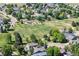 Aerial shot of neighborhood, displaying nearby park with playground and walking path, surrounded by lush trees at 1376 Banner Cir, Erie, CO 80516