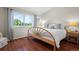 Comfortable bedroom features hardwood floors, a large window with a view, and a light-colored bed with patterned pillows at 1376 Banner Cir, Erie, CO 80516