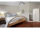 Inviting bedroom features a wood floor, neutral walls, a comfy bed with accent pillows, and a mirror on the closet door at 1376 Banner Cir, Erie, CO 80516