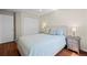 Bright bedroom featuring hardwood floors, soft blue bedding, and a double door closet at 1376 Banner Cir, Erie, CO 80516