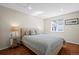 Comfortable bedroom features a window, hardwood floors, a light-colored bed with patterned pillows, and a mirrored nightstand at 1376 Banner Cir, Erie, CO 80516