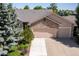 Lovely home featuring a stone facade and a three-car garage with mature trees at 1376 Banner Cir, Erie, CO 80516