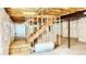 Unfinished basement with a wooden staircase and ample space at 9 Timberlake Ct, Byers, CO 80103
