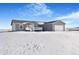Ranch-style home with attached garage and deck, snow-covered yard at 9 Timberlake Ct, Byers, CO 80103