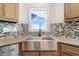 Modern kitchen with farmhouse sink and tile backsplash at 9 Timberlake Ct, Byers, CO 80103