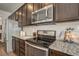 The kitchen showcases stainless steel appliances, granite countertops, and dark wood cabinetry at 17620 Leisure Lake Dr, Monument, CO 80132