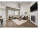 Cozy living room with a fireplace, a ceiling fan, large windows, and stylish furniture at 17620 Leisure Lake Dr, Monument, CO 80132