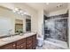 Well-lit bathroom featuring double sinks, a shower with tiled walls, and contemporary fixtures, ensuring comfort and style at 12625 Madison Way, Thornton, CO 80241