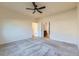 Bright bedroom with neutral carpet, ceiling fan, and an open doorway to bathroom creating an inviting and comfortable atmosphere at 12625 Madison Way, Thornton, CO 80241
