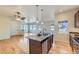 Open kitchen featuring an island with sink, granite countertops, and seamless flow to the spacious living area at 12625 Madison Way, Thornton, CO 80241