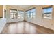 Bright living room with hardwood floors and large windows offering neighborhood views at 12625 Madison Way, Thornton, CO 80241