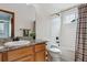 Well-lit bathroom featuring a granite vanity, bathtub, and shower with a patterned curtain at 16420 Martingale Dr, Parker, CO 80134