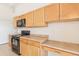 Bright kitchen featuring wood cabinetry and black appliances at 2552 W 82Nd Ln # C, Westminster, CO 80031