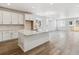 Bright, open-concept kitchen with white cabinets, an island, and wood flooring at 564 Penn Rd, Elizabeth, CO 80107