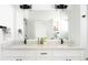 Bright bathroom with double vanity, quartz countertop, black hardware, large mirror, and decor, offering a clean modern design at 385 East St, Louisville, CO 80027