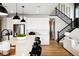 Modern kitchen with stainless steel appliances and an island, flowing into living area and staircase at 8958 Whiteclover St, Littleton, CO 80125