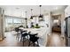 Modern kitchen featuring a large island with seating and sleek pendant lighting at 8958 Whiteclover St, Littleton, CO 80125
