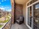 Cozy balcony with a brick accent wall, chair, and sliding glass door offering outdoor views at 15496 W 66Th Dr # B, Arvada, CO 80007