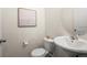 Neat half bathroom featuring a pedestal sink, a toilet, and neutral wall colors for a clean aesthetic at 15496 W 66Th Dr # B, Arvada, CO 80007
