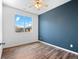 Bedroom showcasing a blue accent wall and hardwood flooring and a window with a view at 15496 W 66Th Dr # B, Arvada, CO 80007