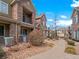 View of townhomes showcasing stone and siding exteriors, well-kept sidewalks, and manicured landscaping at 15496 W 66Th Dr # B, Arvada, CO 80007