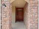 Close-up of a well-crafted front door with sidelight, set within a stone-clad entryway and exterior light fixture at 15496 W 66Th Dr # B, Arvada, CO 80007