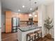 Kitchen featuring an island with stool seating, stainless steel appliances, and wood cabinets at 15496 W 66Th Dr # B, Arvada, CO 80007