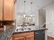 An efficient kitchen featuring granite counters and stainless steel sink, with views of the living area at 15496 W 66Th Dr # B, Arvada, CO 80007