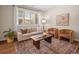 Bright living room featuring stylish furniture, hardwood floors, a large window, and sophisticated decor at 15496 W 66Th Dr # B, Arvada, CO 80007