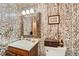 Unique bathroom featuring tree wallpaper, a decorative mirror, and a vanity with ample storage at 3245 S Nucla St, Aurora, CO 80013