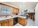 Bright kitchen with light wood cabinets, white appliances, and an island, with access to the adjacent dining room at 3245 S Nucla St, Aurora, CO 80013