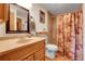 Bathroom featuring a single sink vanity and a shower/tub combination with neutral tiling and shower curtain at 7753 Red Fox Dr, Evergreen, CO 80439