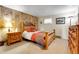 Cozy bedroom features wood paneled walls, a comfortable bed, and plenty of natural light at 7753 Red Fox Dr, Evergreen, CO 80439