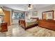 A well-lit bedroom featuring a wooden sleigh bed, hardwood floors, and a window with views of the surrounding forest at 7753 Red Fox Dr, Evergreen, CO 80439