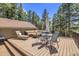 Relaxing outdoor deck with lounge chair, outdoor seating, and views of the surrounding trees at 7753 Red Fox Dr, Evergreen, CO 80439
