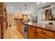 Kitchen boasts an eat-in island, stainless steel appliances, and wood laminate flooring at 7753 Red Fox Dr, Evergreen, CO 80439