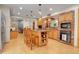Charming kitchen features a center island, wood cabinets, brick arch and wood laminate flooring at 7753 Red Fox Dr, Evergreen, CO 80439