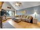 Inviting living room with comfortable sectional couch, ceiling fan, and natural light from the large window at 7753 Red Fox Dr, Evergreen, CO 80439