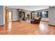 A living room featuring a brick fireplace, wood floors, large window, and comfortable seating at 7753 Red Fox Dr, Evergreen, CO 80439