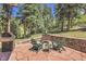 Cozy stone patio with comfortable seating, a grill, and a picturesque natural setting at 7753 Red Fox Dr, Evergreen, CO 80439