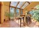 Bright sunroom with skylights, terra cotta tile floor, and a high top table with seating at 7753 Red Fox Dr, Evergreen, CO 80439