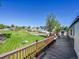 Lush back yard view from the wood deck, showing well-manicured lawn, pathway and landscaping at 7809 S Flower St, Littleton, CO 80128