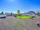 Large gravel area in the backyard, perfect for extra parking, with green grass and white fence at 7809 S Flower St, Littleton, CO 80128