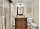 Cozy bathroom featuring a shower, granite vanity, and decorative mirror at 7809 S Flower St, Littleton, CO 80128