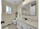 Bright bathroom featuring a white vanity, modern mirror, toilet, and updated fixtures at 7809 S Flower St, Littleton, CO 80128
