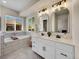 Inviting bathroom with double vanities, arched mirrors, soaking tub, and modern fixtures at 7809 S Flower St, Littleton, CO 80128