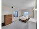 Bright bedroom with two windows and wood furniture including dresser and desk at 7809 S Flower St, Littleton, CO 80128