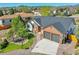Well-maintained brick and white home featuring a lush green lawn, mature trees, and a spacious two-car garage at 7809 S Flower St, Littleton, CO 80128